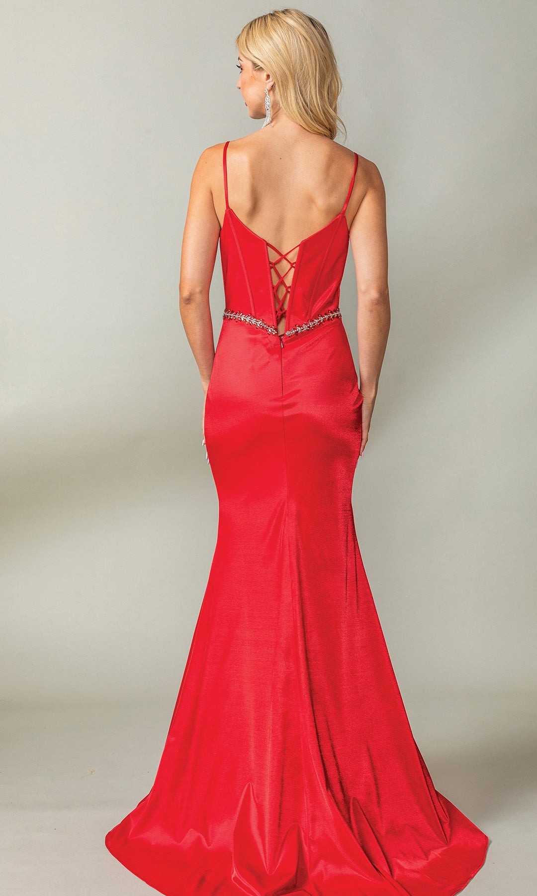 Woman wearing the Beaded-Waist Long Corset-Back Prom Dress 4403, a floor-length fitted red mermaid gown with thin straps, a sweetheart corset bodice, lace-up back, and beaded waist detail, standing against a plain background.